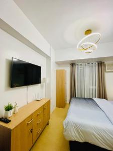 une chambre avec un lit et une télévision à écran plat dans l'établissement Studio Unit with Balcony at Centrio Towers beside Ayala Mall Downtown CDO, à Cagayán de Oro 46 autres photos