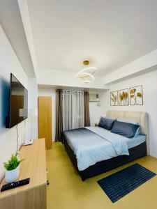 une chambre avec un lit, un bureau et une télévision dans l'établissement Studio Unit with Balcony at Centrio Towers beside Ayala Mall Downtown CDO, à Cagayán de Oro