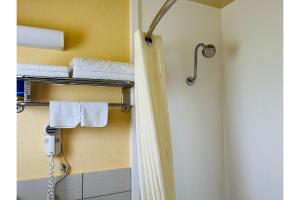 Habitación con baño con ducha y toallas. en Budget inn motel perrysburg oh en Millbury