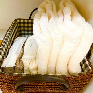 a basket filled with white towels on a table at ゲストハウス西金沢Smile&smile in Kanazawa