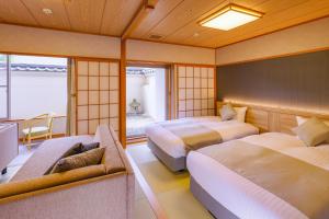 a hotel room with two beds and a couch at TAOYA Akiu in Sendai
