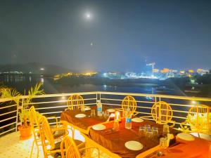 two tables and chairs on a balcony with a view at Atrangi Hotel & lakeview cafe at PICHOLA LAKE by JD in Udaipur