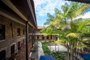 a courtyard with palm trees and a building at Atrium Hotel Quinta De Pedras in Belém
