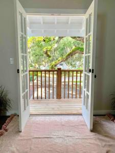 una puerta abierta a un balcón con terraza de madera en StA Hideaway - Upper Unit Apt Minutes From Beach, en St. Augustine