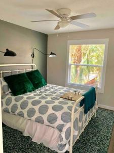 a bedroom with a bed with a fan and a window at StA Hideaway - Upper Unit Apt Minutes From Beach in St. Augustine