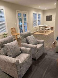 uma sala de estar com um sofá, cadeiras e uma mesa em StA Hideaway - Upper Unit Apt Minutes From Beach em St. Augustine