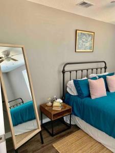 a bedroom with a bed and a mirror at StA Hideaway - Upper Unit Apt Minutes From Beach in St. Augustine