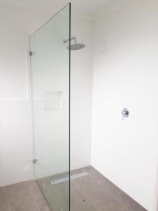 a shower with a glass door in a bathroom at Normanville Getaway House in Normanville