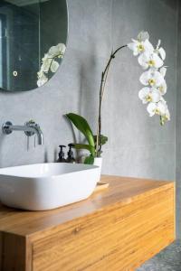 a bathroom with a sink and a flower on a counter at Hyams Beach House B - Brand new lux beach oasis in Hyams Beach