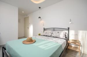 ナクソス・コラにあるDepis apartments & suitesのベッドルーム(ベッド、帽子付)