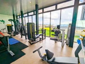 un gimnasio con varias máquinas de correr y una gran ventana en Lovina 1611 at Pollux Meisterstadt, en Batam Centre