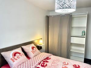 a bedroom with a bed with pink pillows on it at La Sérénade Numéro 2 in Montreuil