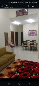 Homestay Rose Guest House 2.0 في غامبانغ: غرفة معيشة مع أريكة وطاولة