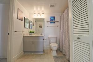 a bathroom with a toilet and a sink and a mirror at Upscale Apartment in the Heart of Brickell in Miami