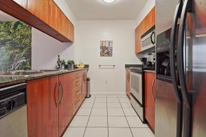 a kitchen with wooden cabinets and a stainless steel refrigerator at Upscale Apartment in the Heart of Brickell in Miami