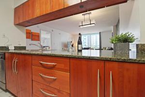 a kitchen with wooden cabinets and a counter top at Upscale Apartment in the Heart of Brickell in Miami