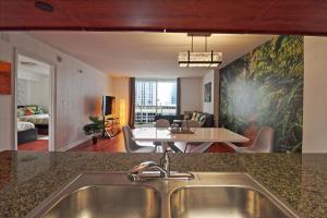 a kitchen with a sink and a living room at Upscale Apartment in the Heart of Brickell in Miami