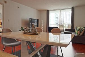 a living room with a dining room table with chairs at Upscale Apartment in the Heart of Brickell in Miami