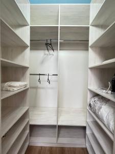 einen begehbaren Kleiderschrank mit weißen Regalen in der Unterkunft 3х-комнатная квартира бизнес класса in Almaty