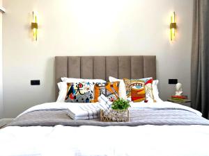 ein Schlafzimmer mit einem großen Bett mit Kissen darauf in der Unterkunft 3х-комнатная квартира бизнес класса in Almaty