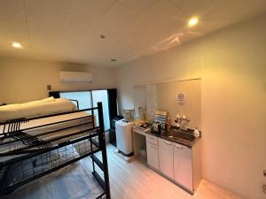 um pequeno quarto com um beliche e uma cozinha em Meguro Apartment em Tóquio