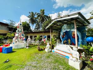 VMJ Inland Resort في Tagum: منزل مع شجرة عيد الميلاد في الفناء
