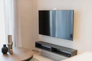 TV de pantalla plana colgada en la pared en ID Residences 102 en Volos