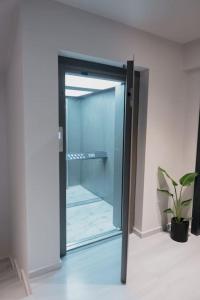 una puerta de cristal abierta en una habitación con una planta en ID Residences 102 en Volos