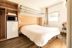 a small bedroom with a bed and a window at KYRIAD DIRECT BRIGNOLES - Provence Verte in Brignoles