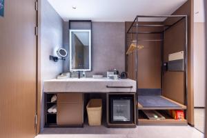 uma casa de banho com um lavatório e um espelho em Atour Hotel Shenzhen Huaqiangbei Commercial Center em Shenzhen