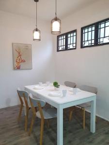 una mesa blanca y sillas en una habitación en 3 Storey Bangalow near Spice Arena & Queensbay Mall, en Bayan Lepas