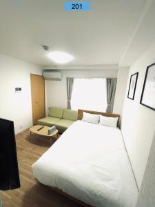 1 dormitorio con 1 cama blanca grande y 1 sofá en Shinjuku area/Family-apartment/4 min to Subway en Tokio