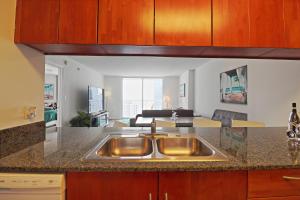 a kitchen with a sink and a living room at Upscale Apartment in the Heart of Brickell in Miami