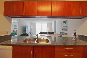 a kitchen with a sink and a living room at Upscale Apartment in the Heart of Brickell in Miami