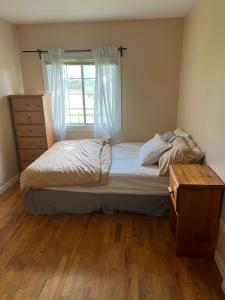 a bedroom with a bed with a window and a dresser at Farm House - L&S Farms in Chilliwack
