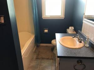 La salle de bains est pourvue d'un lavabo, d'une baignoire et de toilettes. dans l'établissement Farm House - L&S Farms, à Chilliwack