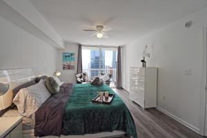 a bedroom with a bed with a green blanket and a window at Upscale Apartment in the Heart of Brickell in Miami