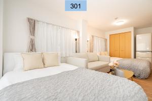 a white bedroom with a bed and a couch at Shinjuku area/Family-apartment/4 min to Subway in Tokyo