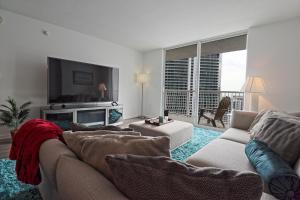 a living room with a couch and a tv at Upscale Apartment in the Heart of Brickell in Miami