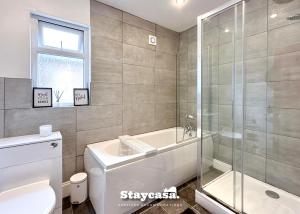 a bathroom with a shower and a toilet and a sink at Homely 4-bedroom House in Manchester