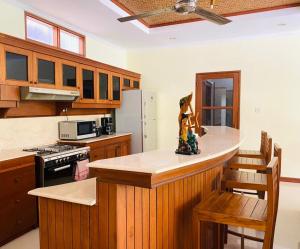 a kitchen with wooden cabinets and a counter top at Bali Jade Villas in Sanur