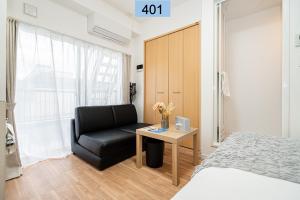 1 dormitorio con cama, silla negra y mesa en Shinjuku area/Family-apartment/4 min to Subway en Tokio