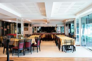 um restaurante com mesas e cadeiras e um bar em Grand Ratchapruek Hotel em Ban Bang Phlap