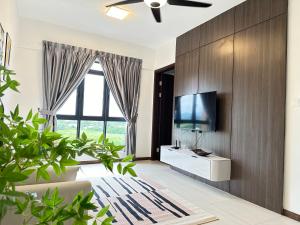 een woonkamer met een groot raam en een flatscreen-tv bij K Avenue by BeMy guest in Kota Kinabalu