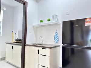 a kitchen with a sink and a refrigerator at K Avenue by BeMy guest in Kota Kinabalu