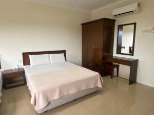 una camera con letto, cassettiera e specchio di OYO 90896 Gold Hill Hotel a Jerantut