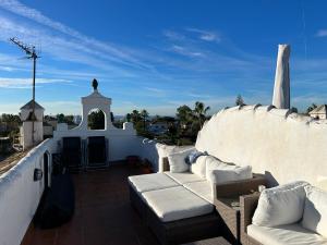 a balcony with white couches on a white wall at Mi Sitio in Sitio de Calahonda