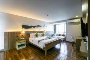 a bedroom with a large bed and a living room at Grand Ratchapruek Hotel in Ban Bang Phlap