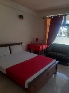 1 dormitorio con cama, mesa y ventana en Eventide Beach Resort en Marawila