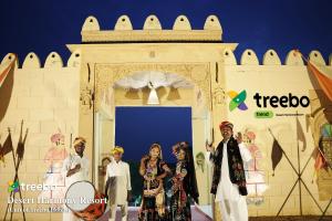 Treebo Trend Desert Harmony Resort في Sām: مجموعة أشخاص واقفين أمام مبنى